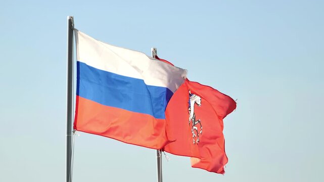 Russian national flag and Moscow city flag flying together on a clear day