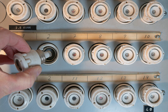 Hand of unrecognizable person connecting fuse in electrical panel