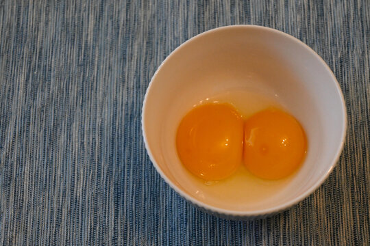 Two raw egg yolks in a bowl