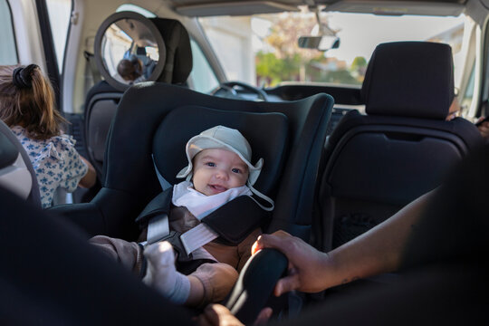 Portrait of cute baby wearing hat while sitting in car seat
