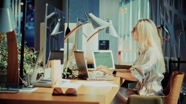 Employee Typing On Laptop Computer At Office Desk