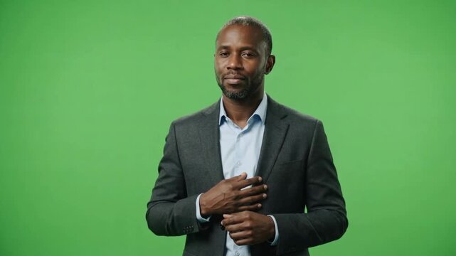 A confident man in a tailored suit with a calm expression standing against a vibrant green background