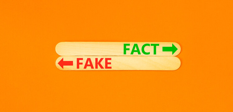 Fact or fake words symbol. Concept words Fake and Fact on beautiful wooden sticks. Beautiful orange background. Business and fact or fake concept. Copy space.