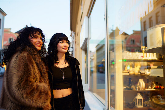 Excited lesbian couple looking at merchandise inside store window
