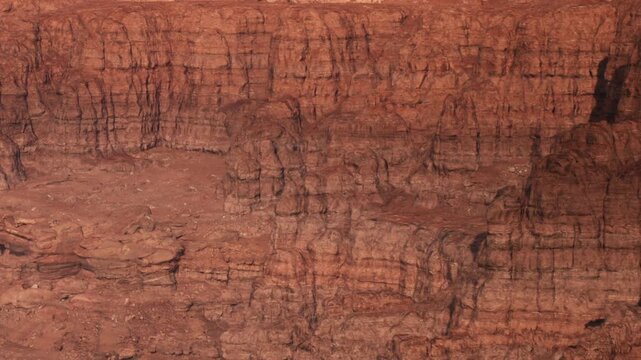 Large red rock formations in a desert area under bright sunlight. The rocks display various patterns and textures. This location has natural features typical of desert scenery.