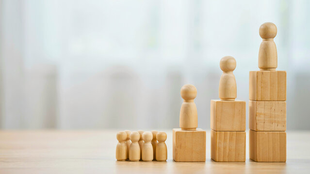 Wooden People Figures on Increasing Block Heights Representing Success and Growth