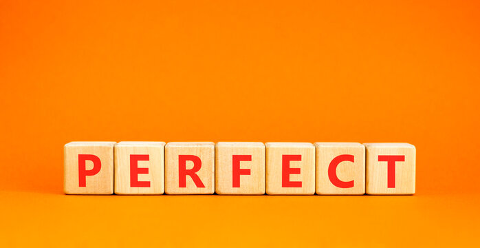 Perfect word symbol. Concept word Perfect on beautiful wooden blocks. Beautiful orange table orange background. Business perfect word concept. Copy space.