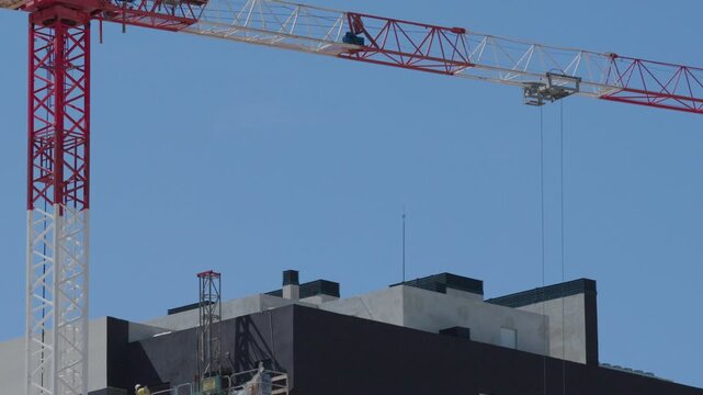 Tower crane operator moving trolley on construction site