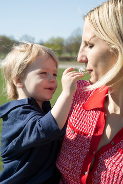 Blond mother spending leisure time with son at sunny day