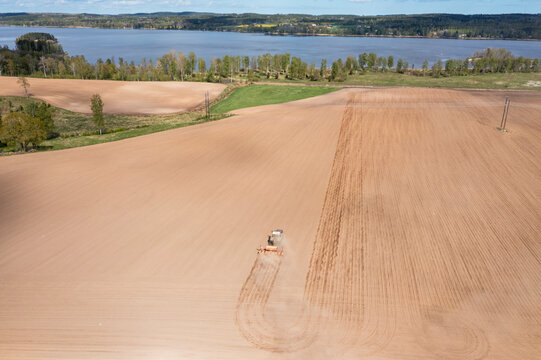 Aerial view of tractor plowing agricultural field at rural location