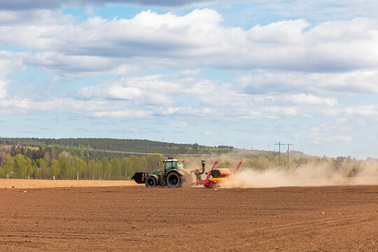 Tractor plowing agricultural field under cloudy sky