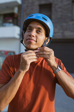Young man puts on a cycling helmet