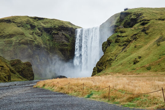 Waterfall flowing down cliffs with grassy hills