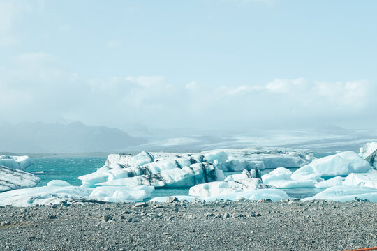 Floating icebergs and glacier fragments create a cold scenic shoreline