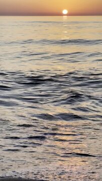 Beautiful sunset over the sea o ocean waves with an orange sky.
