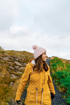 White Woman smiling and walking outdoors on a rocky path