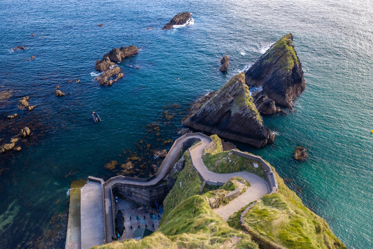 Aerial view of winding pathway at Dunquin Pier on Dingle Peninsula in Ireland. Aerial view of serpentine path of Dunquin Pier along Wild Atlantic Way.