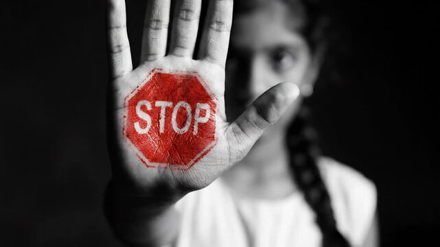 Young girl holds hand up with stop sign on palm protest message warning