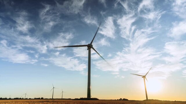 Timelapse of Wind Turbines Rotating in Agricultural Field Under Cirrus Clouds at Sunset Renewable Green Energy Park