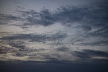 Cloud formations drift slowly through a quiet dusk sky. © Sumith