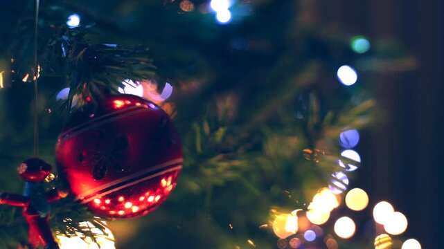 addobbi natalizi su un albero di natale in primo piano, bassa profondit&agrave; di campo con sfondo sfuocato, luci colorate e brillanti ed effetto bokeh