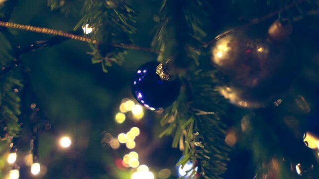 addobbi natalizi su un albero di natale in primo piano, bassa profondit&agrave; di campo con sfondo sfuocato, luci colorate e brillanti ed effetto bokeh