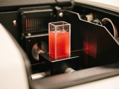 Laser spectrophotometer measuring color density of red juice cuvette