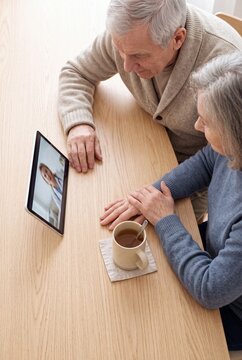 Senior Couple Having an Online Telehealth Consultation with a Doctor on Digital Tablet at Home