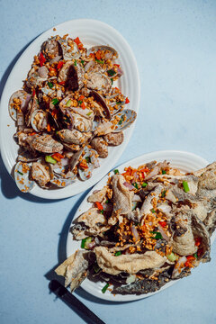 Malaysian street food with spicy clams and crispy fish skin