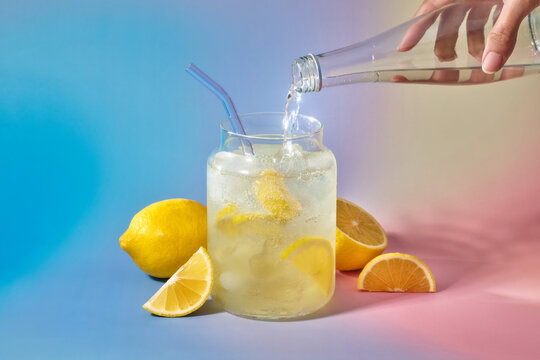 A refreshing glass of lemonade being prepared with a splash of water