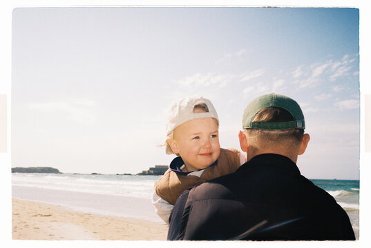 Dad holding son on a sandy beach
