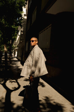 Man turning back with briefcase in dramatic street editorial