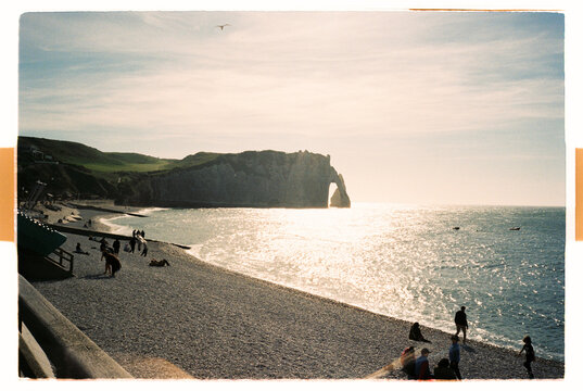 Etretat sea arch and pebble beach in evening sunlight