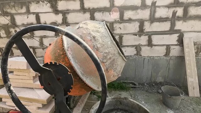 A Close-Up View of a Concrete Mixer Working at a Construction Site, Showcasing Equipment and Materials in a Busy Environment