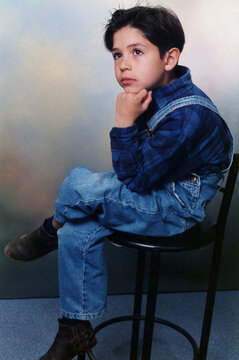 Young boy sitting thinking having curious expression