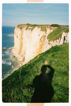 White coastal cliffs with photographer shadow