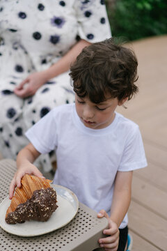 Kid savoring fresh chocolate pastry