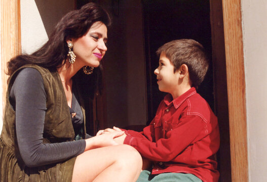 Woman and young boy sharing tender moment, holding hands