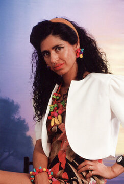 Woman posing wearing bold 80s fashion and colorful accessories