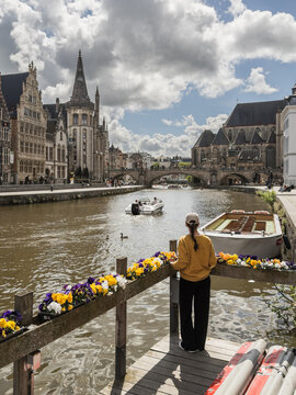 Woman Tourist Standing by Scenic Canal at Korenlei in Ghent Belgium