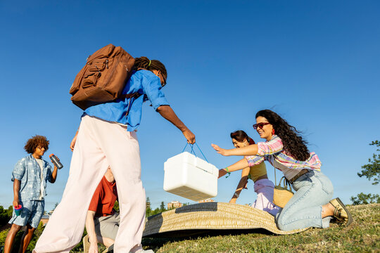 Friends settling for picnic in the park