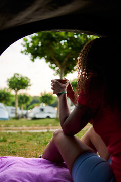 Woman enjoying morning coffee at campsite opening