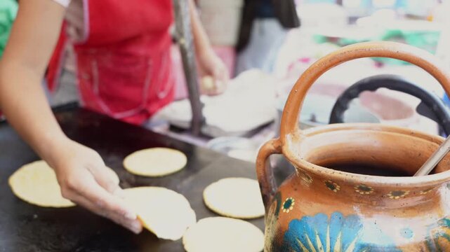 Street food vendor making fresh corn tortillas on a comal