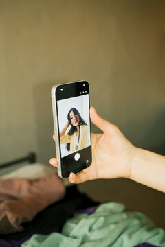 Smartphone screen showing selfie of young beautiful asian woman