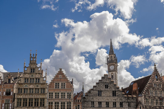 Medieval Guildhouses and Clock Tower Under Blue Sky in Ghent Belgium