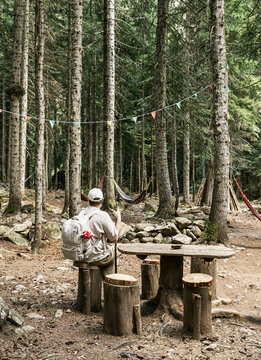 Hiker resting at rustic forest campsite