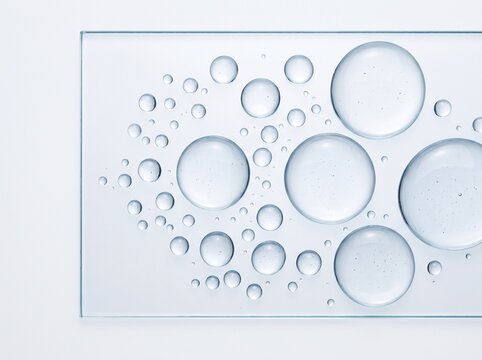 Top Down Flat Lay View of Clear Water Droplets Spread Across Transparent Glass Surface
