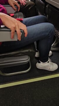 Two passengers prepare for takeoff on a flight with hands resting on the armrests in a close-up view