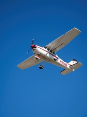 Obraz premium Small Propeller Airplane Flying in a Clear Blue Sky - Single Engine Private Aircraft in Flight