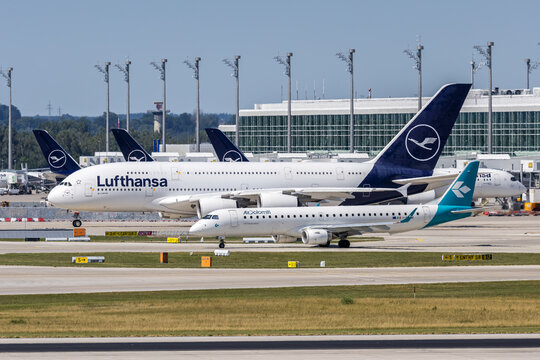 Air Dolomiti Embraer 195 and Lufthansa Airbus A380-800 airplanes at Munich airport in Germany